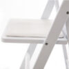 Close up view of white resin padded folding chair