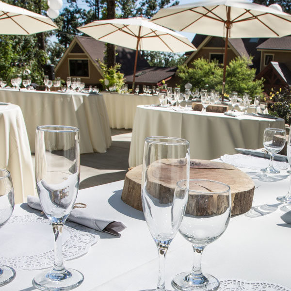 Outdoor event uses market umbrella, round and rectangular tables and glassware