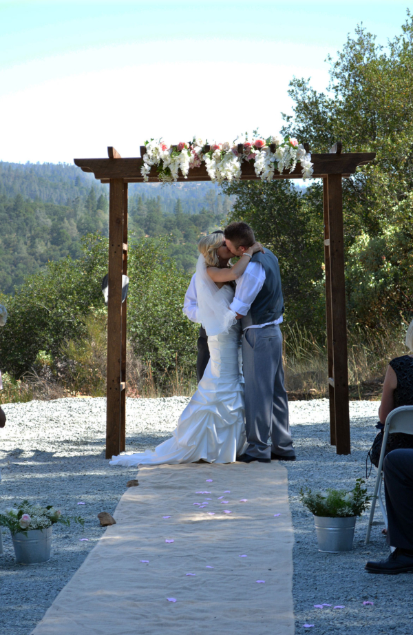 Bride and groom under the fruitwood arch.